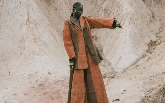 Brown outfit pointing with gold bangles