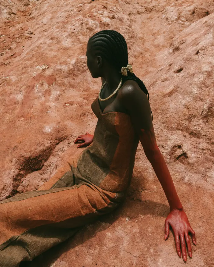 Sitting on red earth with red paint arm